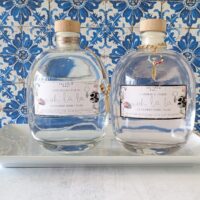 Large, unique round glass bottle of Cashmere & Jasmine scented luxury bubbly bath with a gold leaf charm.